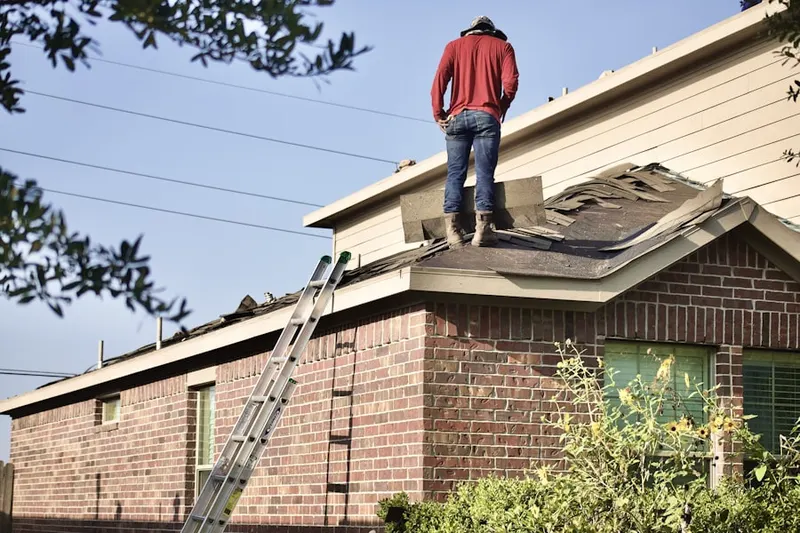 Professional roofer working on a residential roof in Fair Hills